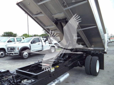 Isuzu NPR-HD dump truck rear with raised bed showing chassis and fuel tank area, side view of the dump body and wheel