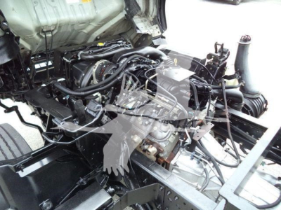 Isuzu NPR-HD engine bay view showing exposed engine and components in a truck frame.