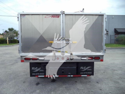 Rear view of a Isuzu NPR HD truck box with Voth logo on doors and taillights, showing rear bumper and mudflaps
