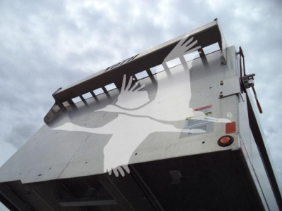 Isuzu NPR-HD truck bed edge and hoist tailgate showing hydraulic mechanism and warning stickers.