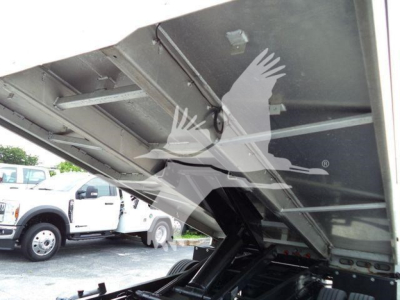 Isuzu NPR-HD truck bed raised showing hydraulic lift and underside components.