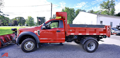 Truck side view showing a red 2019 Ford F-550 dump bed with crane/loader on the rear, in-service body, wheel wells, and dump bed side rails visible.