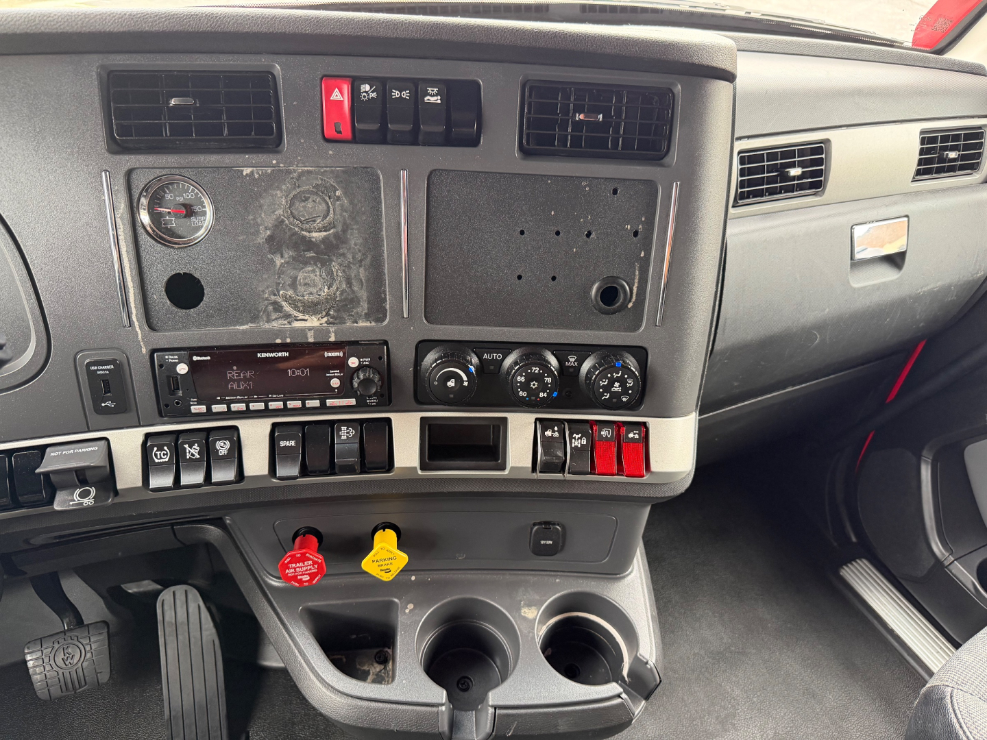 Kenworth T680 truck dashboard cab interior with control panel and cup holders.