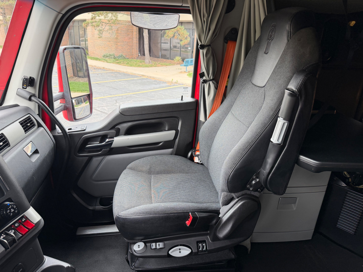 Kenworth T680 truck interior driver's seat and dash area with grey fabric seat.