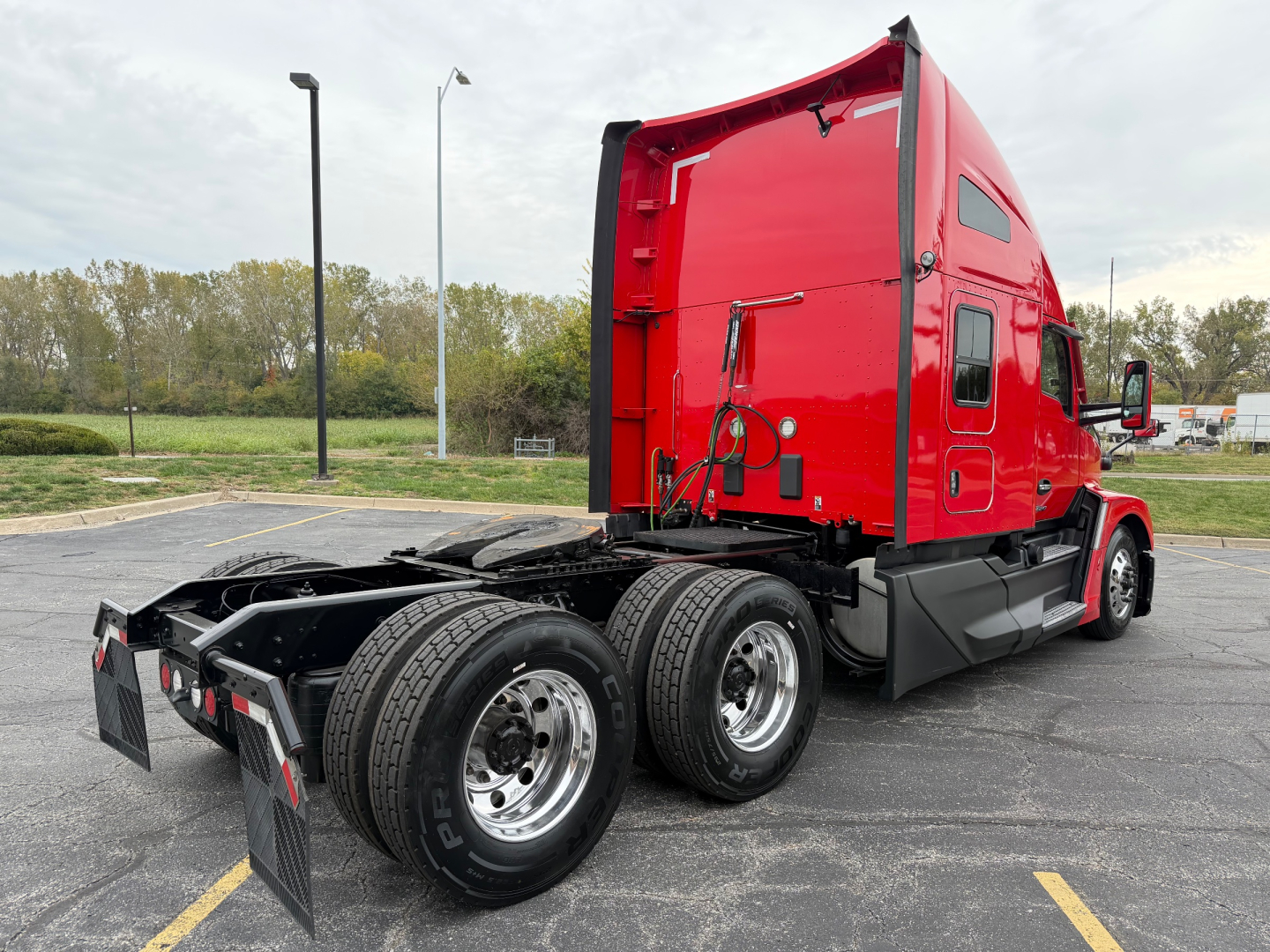 Kenworth T680 truck in red sleeper cab viewed from rear quarter with dual rear axles and fifth wheel, stock number 0635680, VIN 1XKYD49X1PJ229990.