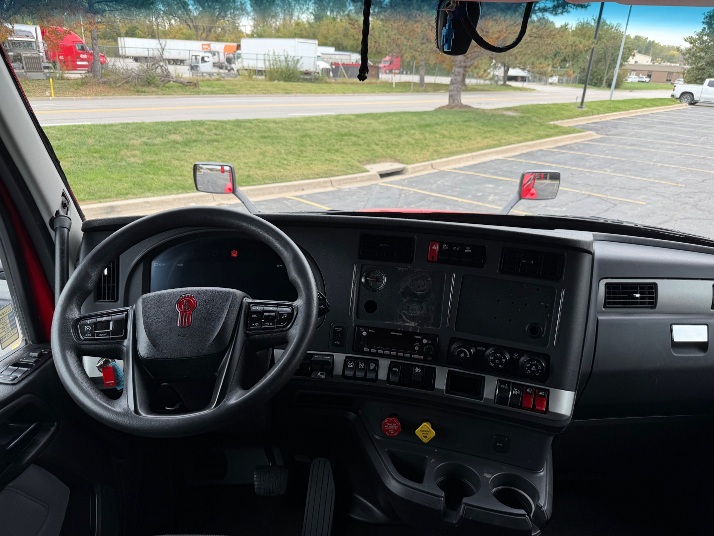Kenworth T680 truck interior view from driver seat with dashboard controls and steering wheel.