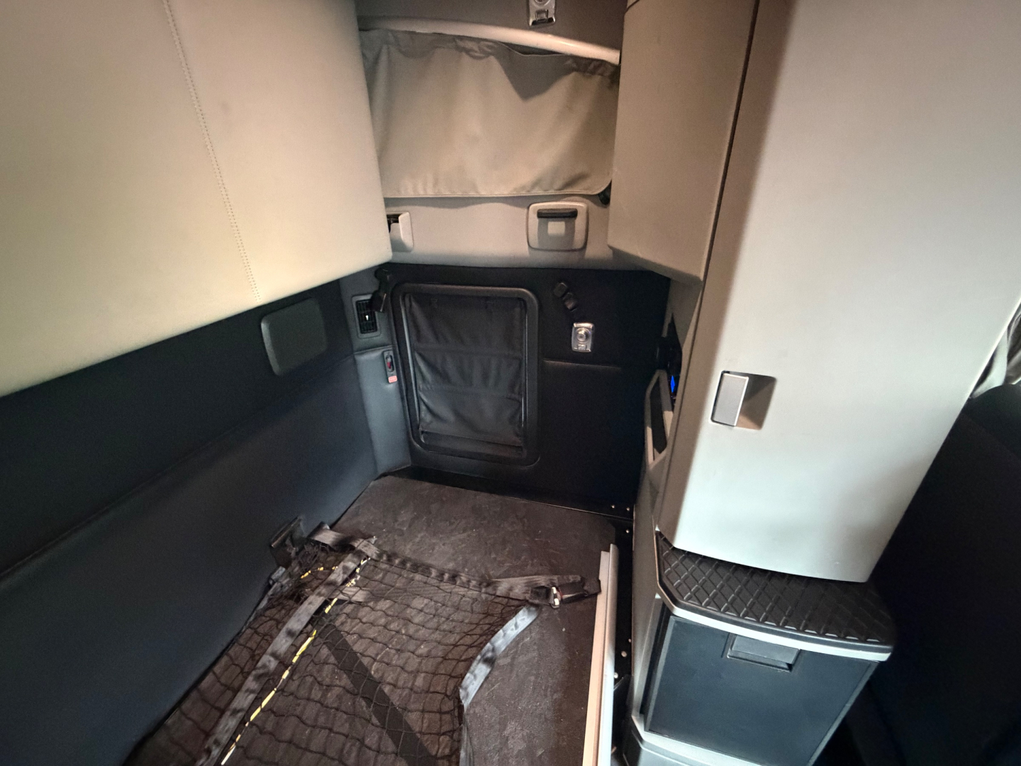 Kenworth T680 interior cargo area view with sleeper cab, cabin side paneling, and storage door.