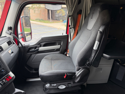 Kenworth T680 truck interior driver's seat and dash area with grey fabric seat.