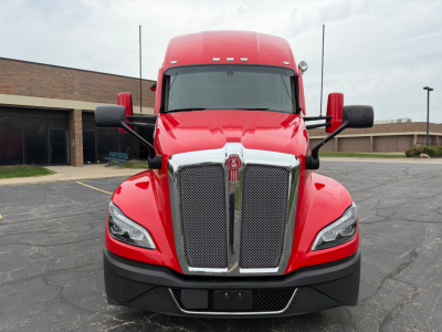 Front view of a red Kenworth T680 truck showing large chrome grille, headlights, and bumper.
