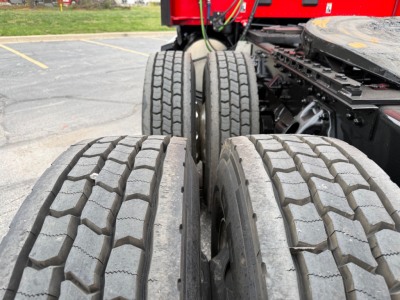 Dual rear truck tires with tread pattern, part of a Kenworth tractor-trailer chassis.