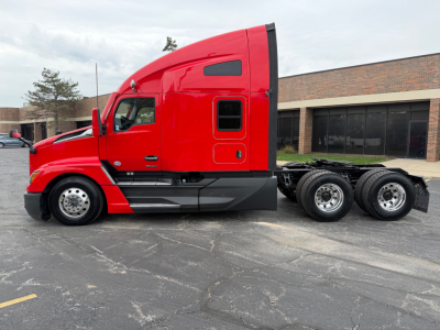 Kenworth T680 tractor cab in red, side view showing sleeper area and rear tandem wheels.