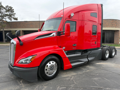 Kenworth T680 sleeper tractor in red with dual rear axles; front shows large chrome grille and headlamp; side shows door with window and mirror; no visible text readable on the vehicle.