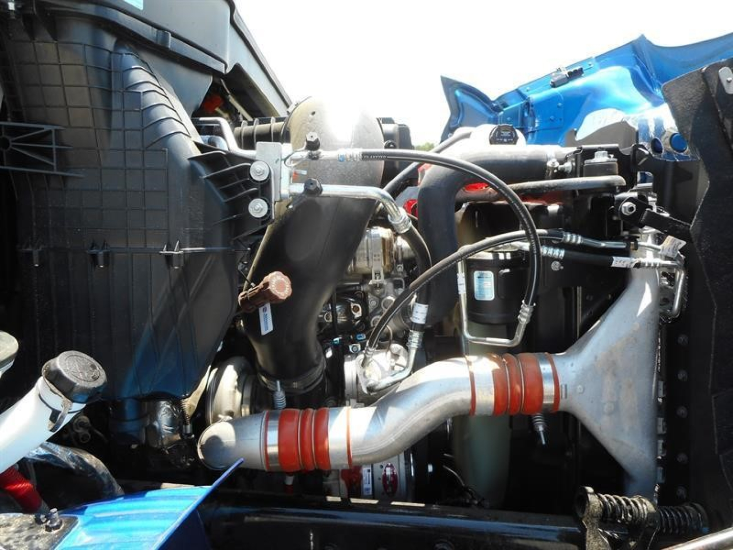 Engine bay and turbocharger of a new Western Star 47X dump truck showing intake piping, hoses, and components.