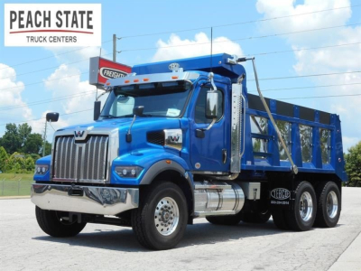 Western Star 47X dump truck in blue, front three-quarter view, showing chrome grille, dual rear axles, and polyethylene dump body. Peach State Truck Centers logo top left.
