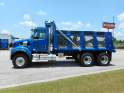 Western Star dump truck side view showing blue cab and dump bed with chrome steps and heavy-duty tires.