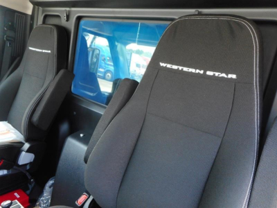 Interior of a 2027 Western Star 47X truck showing black fabric seats with white stitching and 'WESTERN STAR' embroidered on headrests.