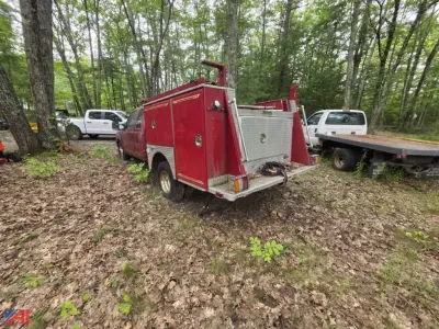 Ford F-350 Super Duty mini pumper fire truck rear view showing red body with equipment compartments and silver rear step area.