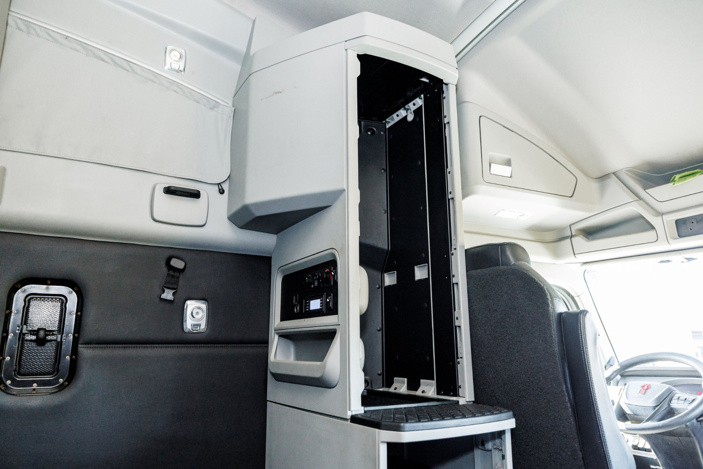 Kenworth T680 interior cab area showing center console open with storage compartments and dashboards