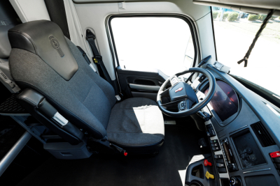 Kenworth T680 truck cab interior with steering wheel and driver seat, dashboard controls visible.