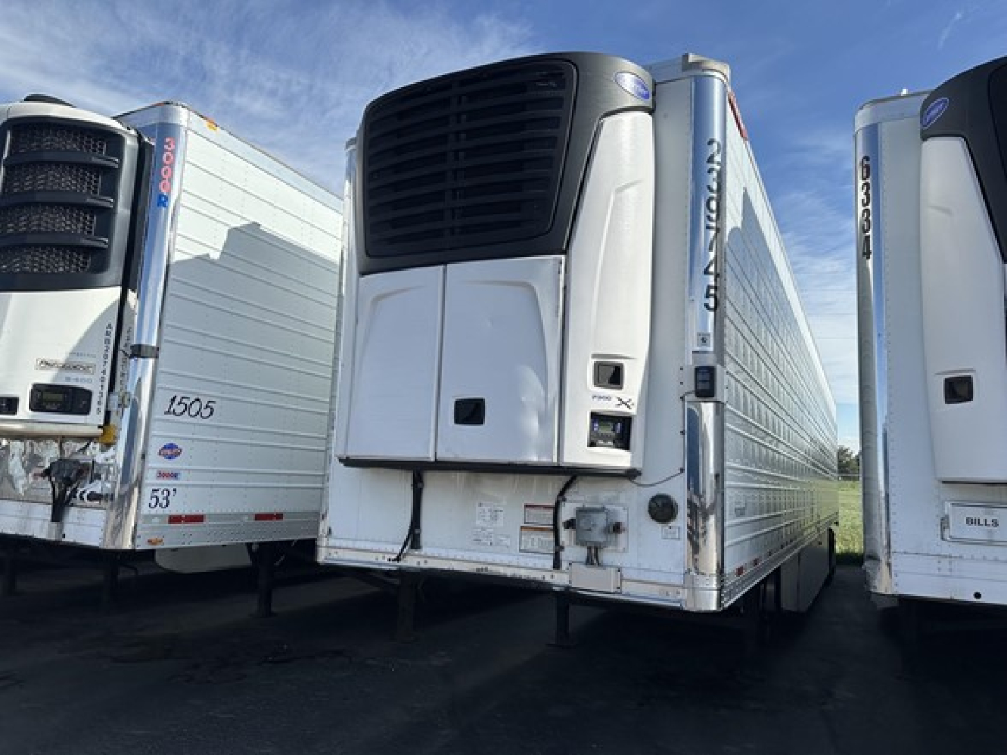 Great Dane air ride reefer trailer with black cooling unit and white insulated body, adjacent trailers in yard, stock number UE11683 visible.