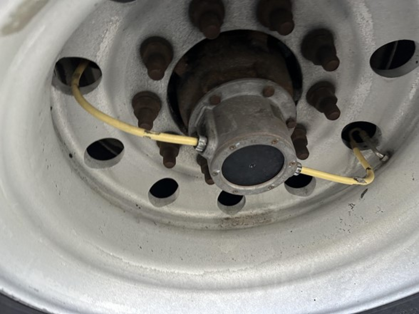 Wheel hub of a Great Dane air-ride reefer trailer showing hub with bolts and yellow electrical wiring connected to a circular cap.