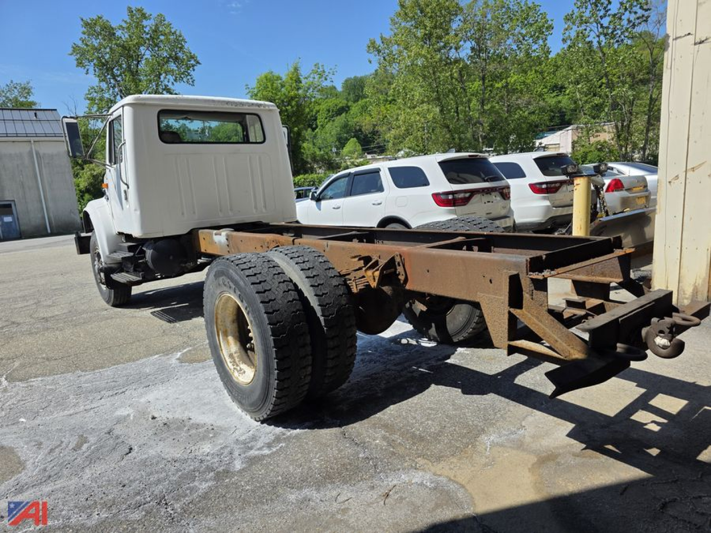 In-service 1991 International 4700 cab and chassis showing bare chassis frame with dual rear wheels and standalone cab.