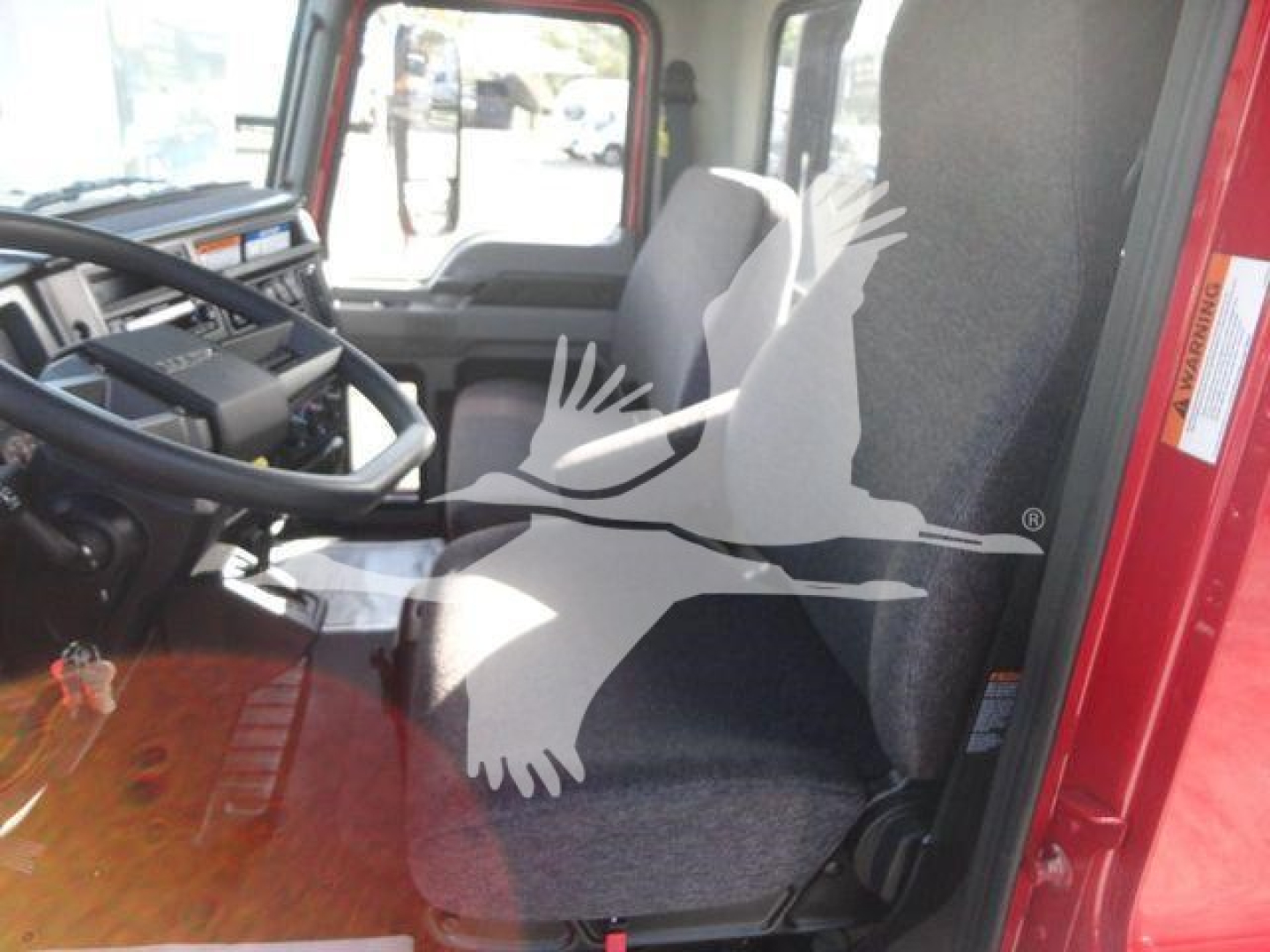 Cab interior of a 2027 Mack MD6 truck showing seating and steering wheel.
