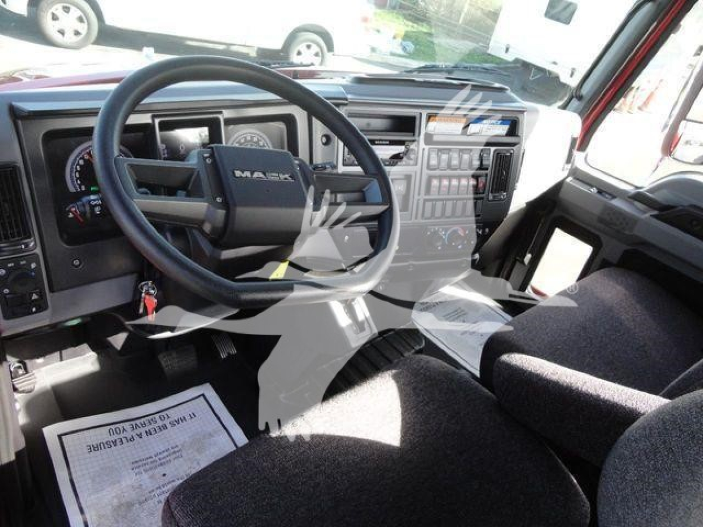 Dashboard and steering wheel of a new 2027 Mack MD6 roll-back truck showing instrument panel and center console.