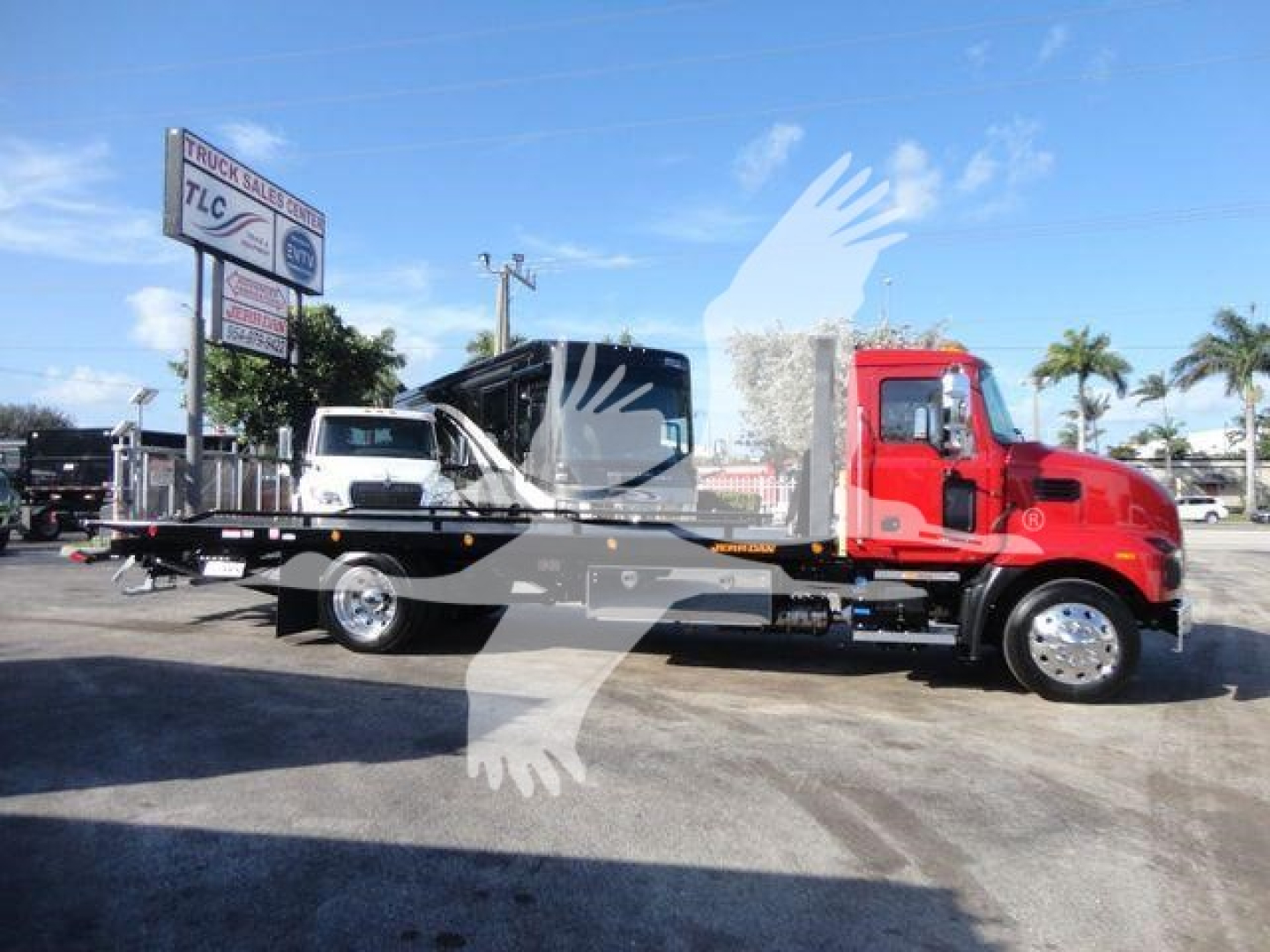 2027 Mack MD6 rollback tow truck in red cab with flatbed, shown in side view under clear sky.