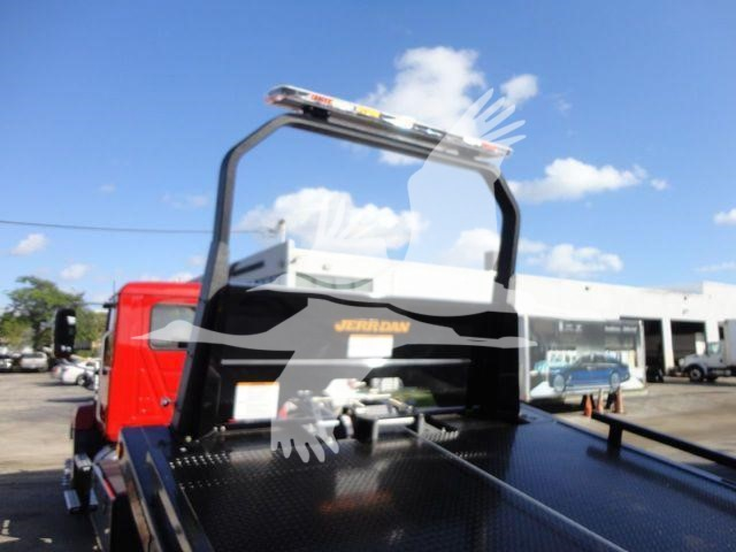 2027 Mack MD6 rollback truck with elevated rear dolly and metal deck, front cab red, side view shows MD6 badge on black frame and skull decal overlay.