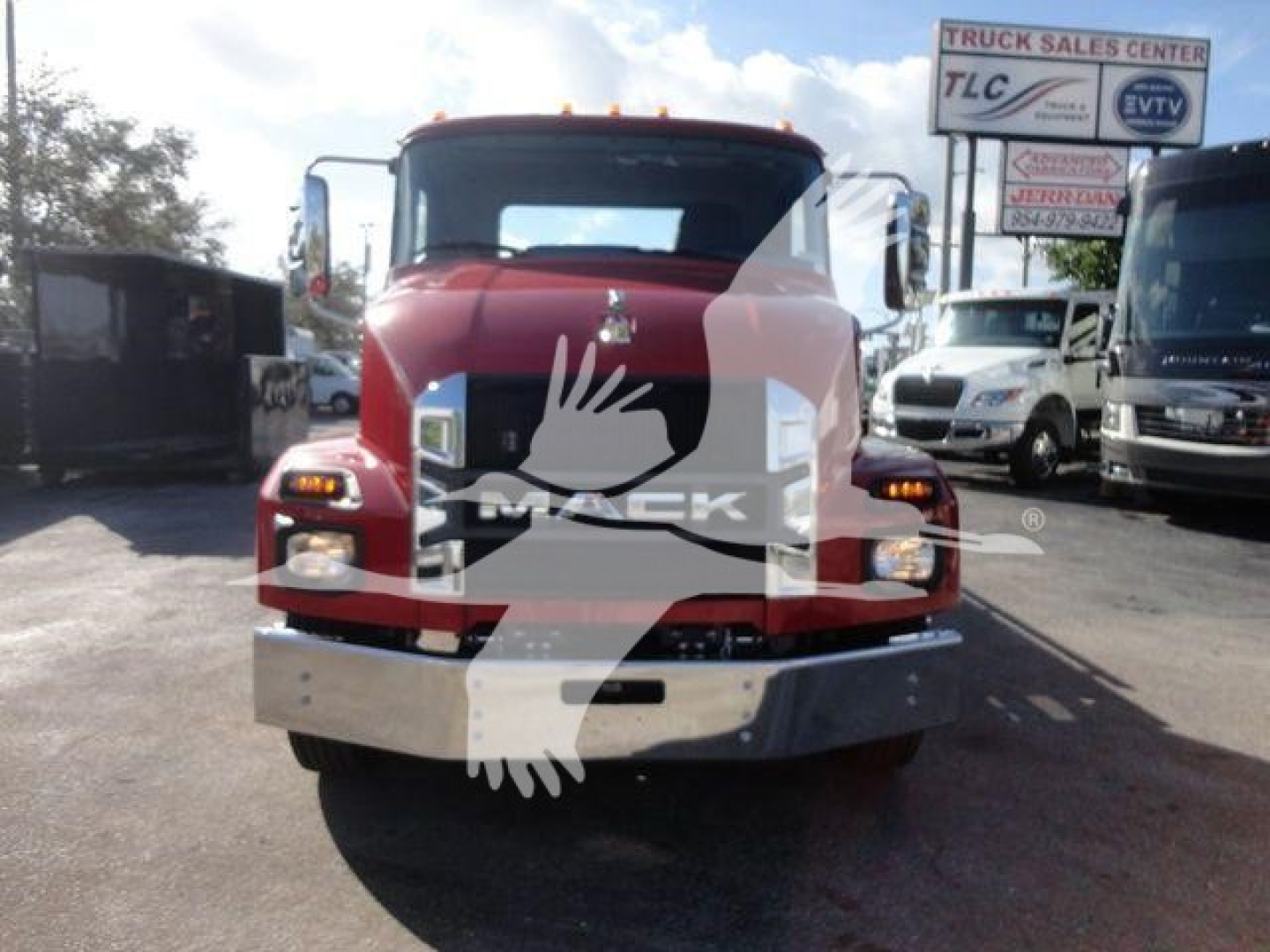 Front view of a red 2027 Mack MD6 rollback truck showing Mack logo on grille and chrome bumper.