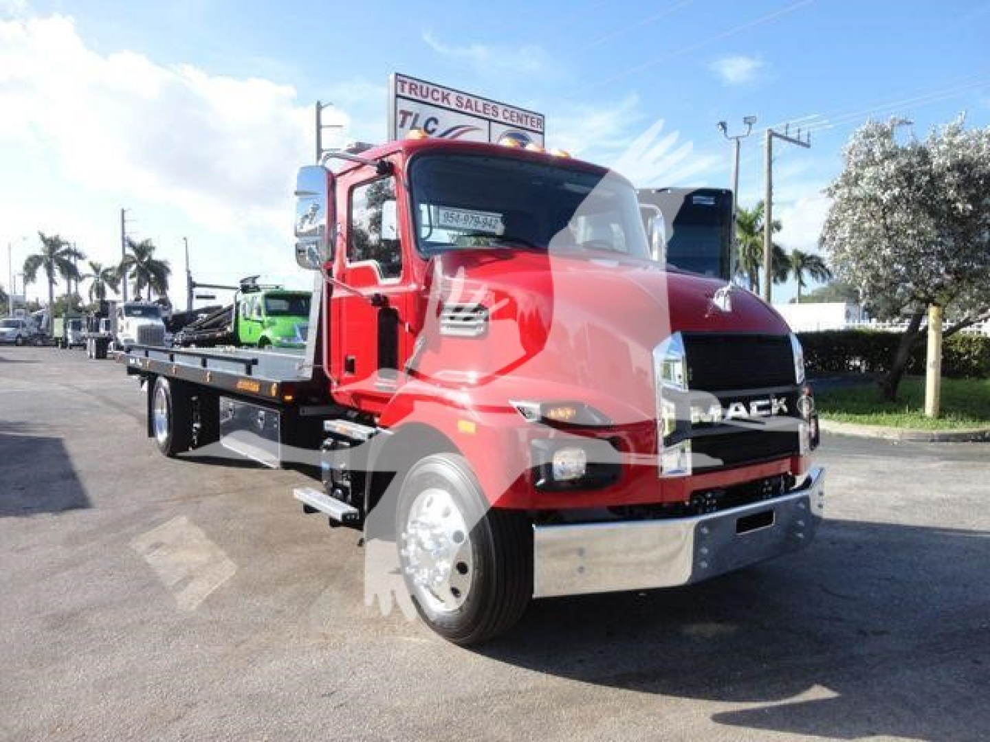 MD6 truck in red with rollback bed, side view showing Mack grille and chrome bumper