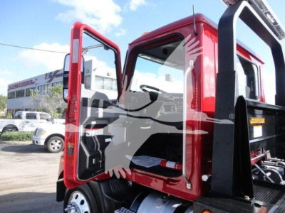 MD6 cab open door showing interior and red exterior with rollback equipment in background.