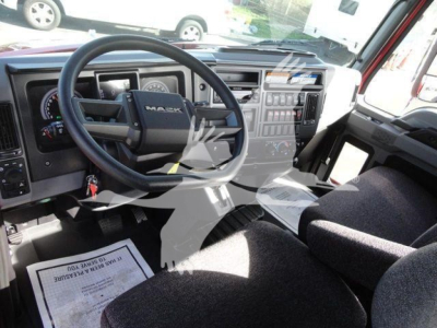 Dashboard and steering wheel of a new 2027 Mack MD6 roll-back truck showing instrument panel and center console.