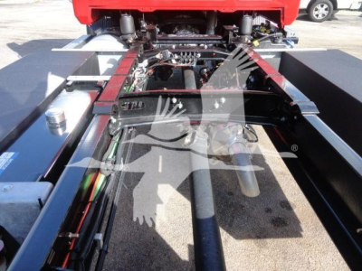 View under a 2027 Mack MD6 rollback truck showing chassis components and hydraulic lines.