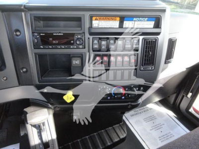 Dashboard of a 2027 Mack MD6 rollback truck showing instrument panel, warning labels, controls, and radio unit