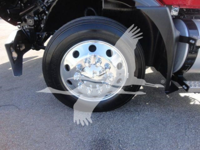 MD6 truck front wheel assembly showing chrome steel hub with lug nuts and large black tire; part of the front axle and fender in view.