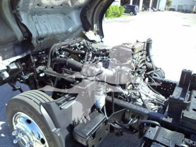 Isuzu NPR XD truck chassis with exposed engine bay and transmission; various hoses, battery, and components visible under hood.