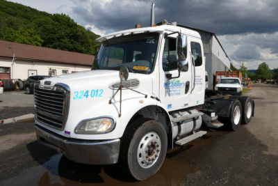 2007 Freightliner M2 112 conventional daycab truck in a salvage yard, white with blue stock number 324 012 on the passenger door and a McColllister's decal, VIN 1FUJC5DL87HX81707 visible in listing context.