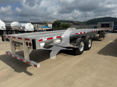 Flatbed trailer showing Benson branding, dual rear axles, metal deck with reflective stripes, side rails, and rear bumper lights.