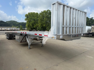 Flatbed trailer showing rear ramp and side rails with metal support legs.
