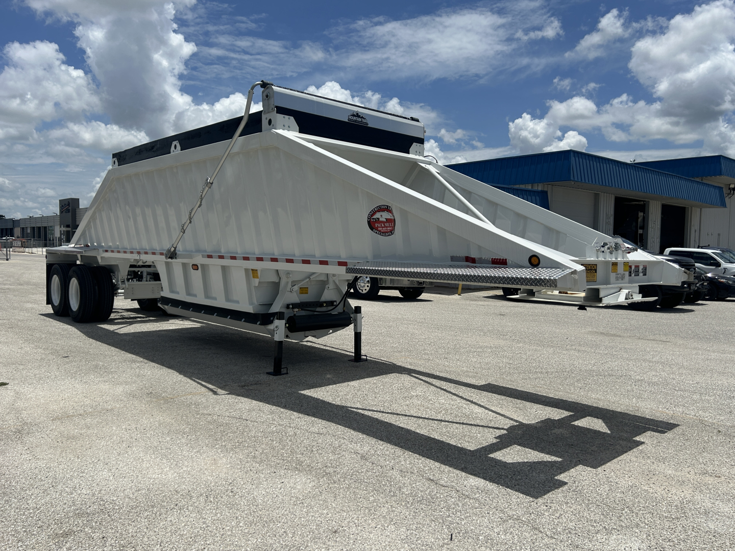 Trailer side view showing CTS BDT-40 dump trailer with white body and dual rear axles.