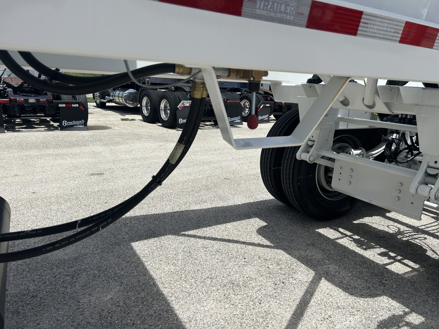 Trailer chassis and suspension components showing hydraulic hoses and frame of a new CTS BDT-40 trailer, with wheels and undercarriage visible.