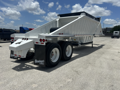 Dump trailer showing white CTS BDT-40 spring dump trailer with dual rear wheels and gooseneck style hitch. Visible text on mudflaps reads Benkro? Brock? 'Bruckner' brand. License plate area not readable.