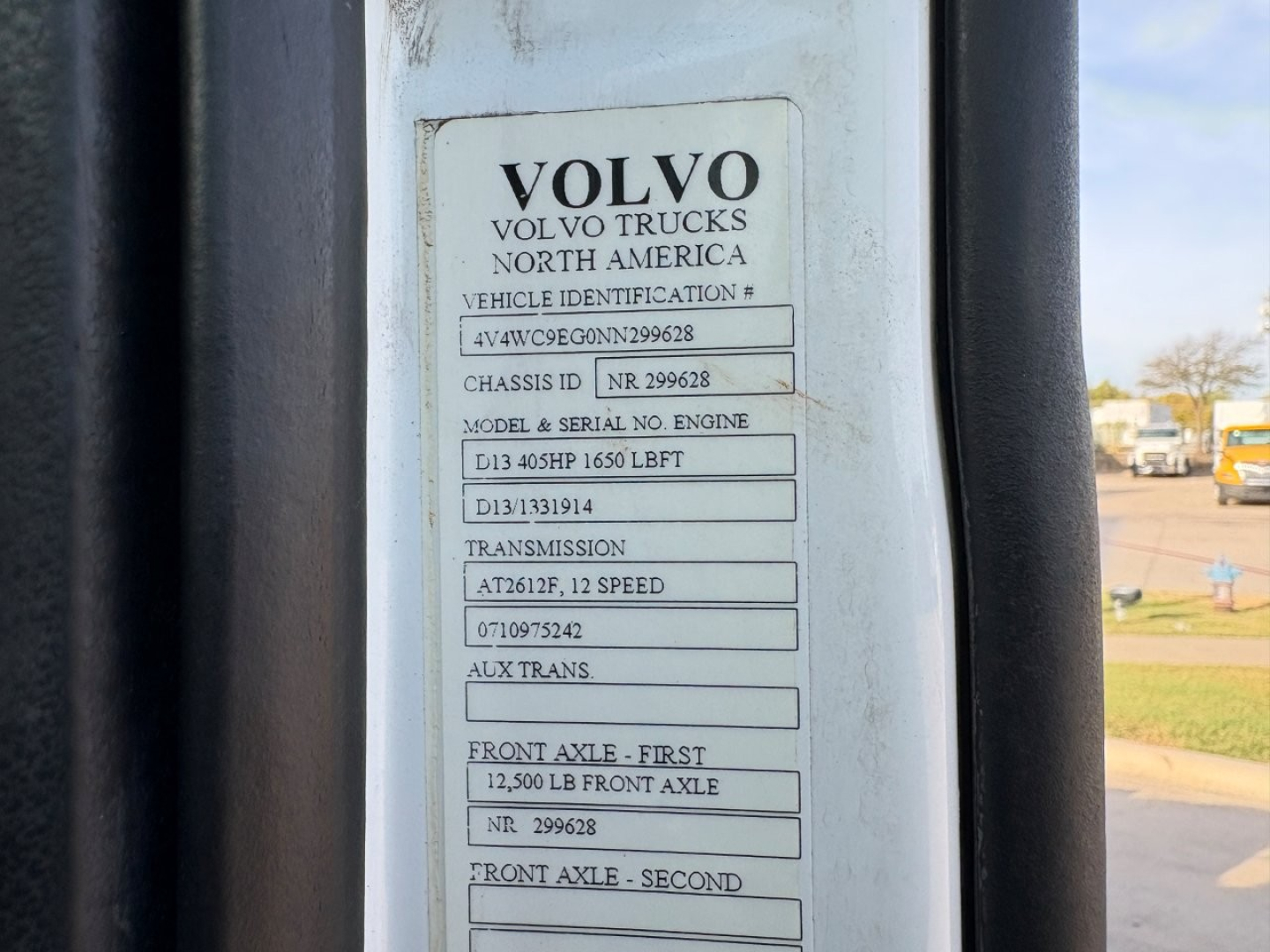 Volvo truck door VIN plate showing Vehicle Identification Number 4V4WC9EG0NN299628, chassis and engine details, transmission at 12 speed, front axle 12,500 lb, auxiliary trans.