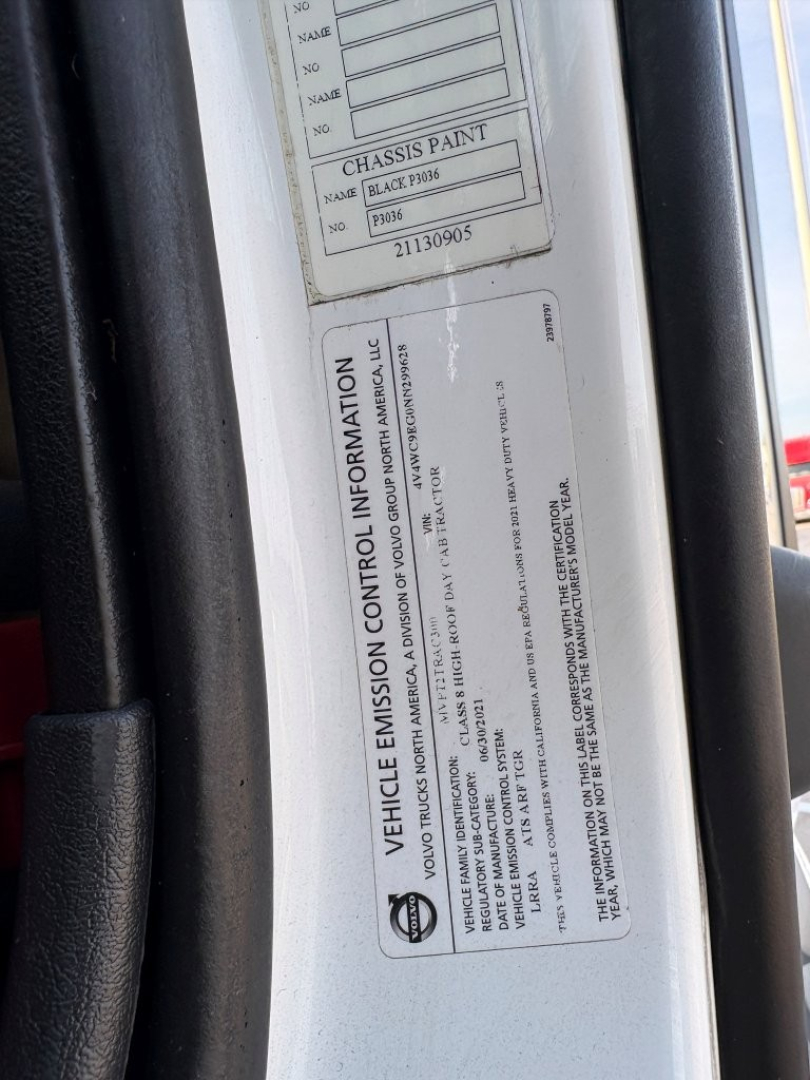 Vehicle emission control information label on a Volvo truck door jamb with VIN and engine info visible.