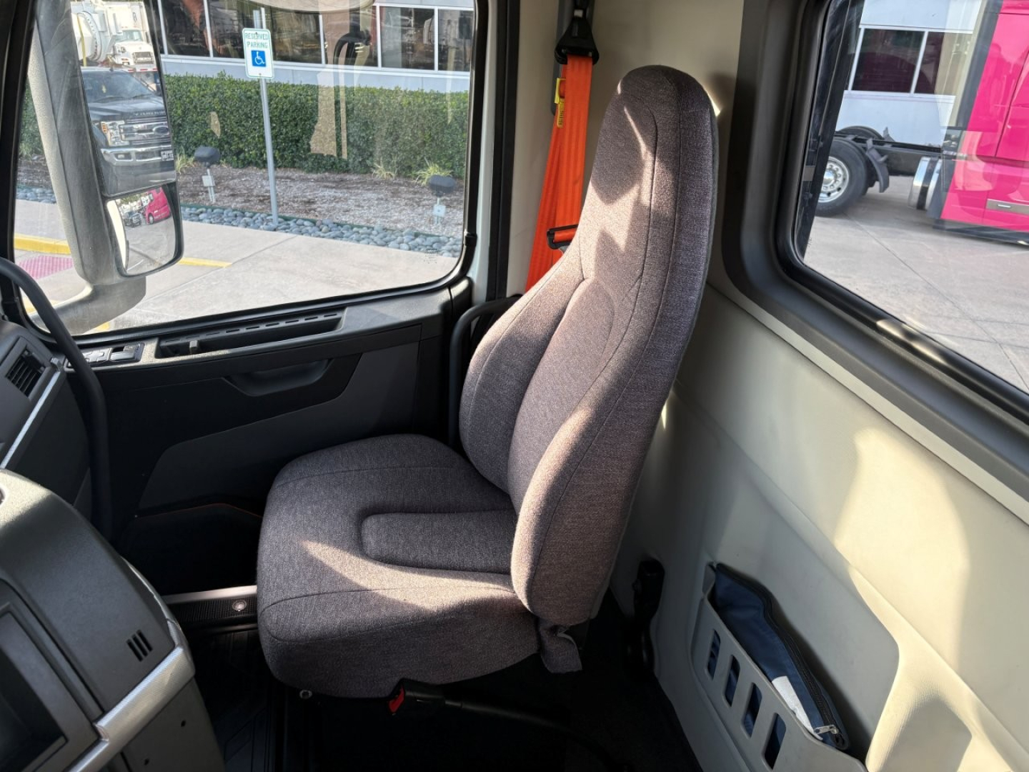 Cab interior of a 2022 Volvo VNR truck showing driver's seat and window view.