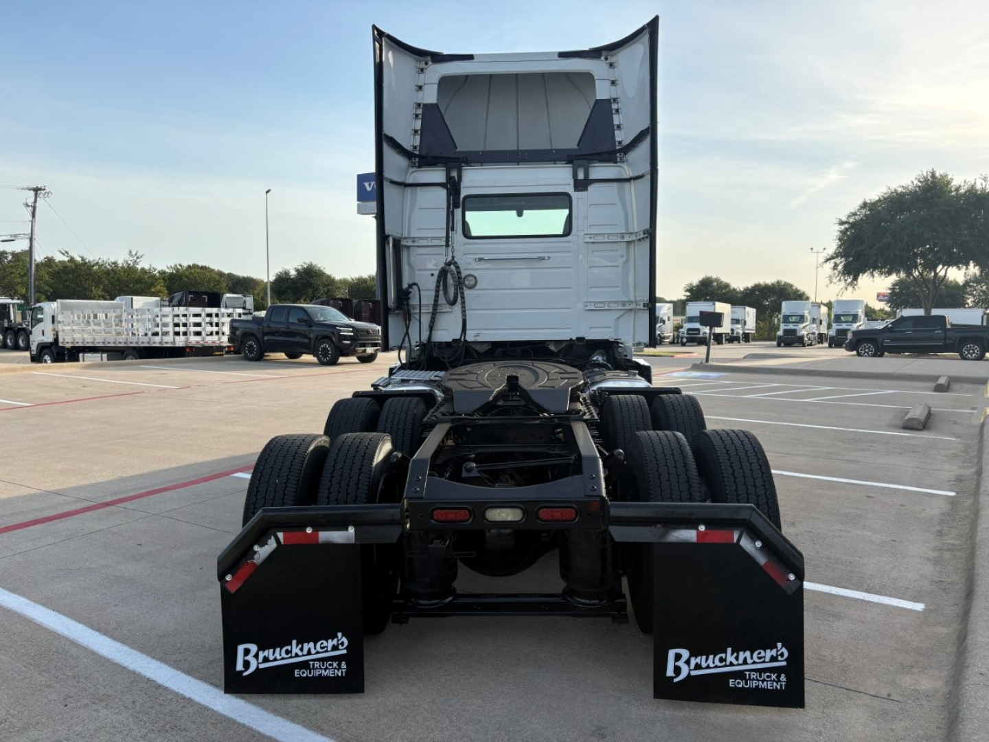 Truck chassis and rear view of a 2022 Volvo VNR64T300 tractor in a dealership lot, rear wheels visible, high cab back.