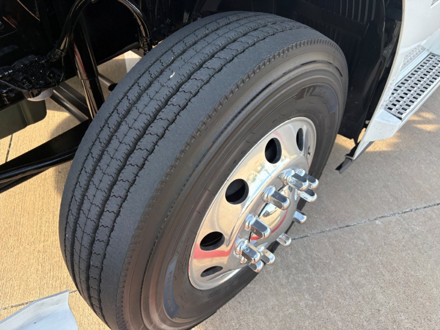 Volvo VNR64T300 wheel and tire assembly showing steel hub with multiple lug nuts and treaded tire.