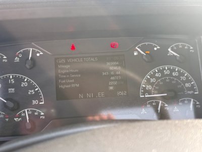 Instrument cluster of a Volvo VNR truck showing dashboard display with Vehicle Totals data and gauges around.
